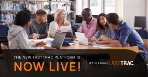 A cohort of adults sit at a table with papers and laptops in a library. The text overlay reads: "The new FastTrac platform is now live! Kauffman FastTrac."